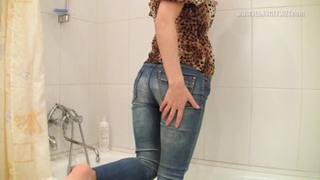 Девушка в джинсах под душем